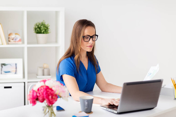 happy woman with laptop working at home or office - Foto, Imagem
