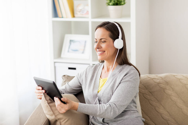happy woman with tablet pc and headphones at home - Foto, immagini