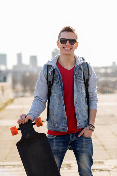 happy young man or teenage boy with longboard - Zdjęcie, obraz
