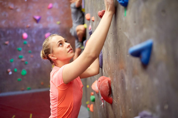 young woman exercising at indoor climbing gym wall - Foto, afbeelding