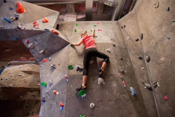 young woman exercising at indoor climbing gym - Fotó, kép