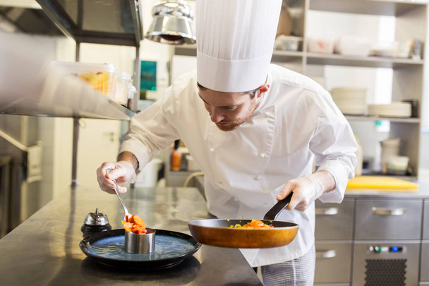 happy male chef cooking food at restaurant kitchen - Foto, Bild