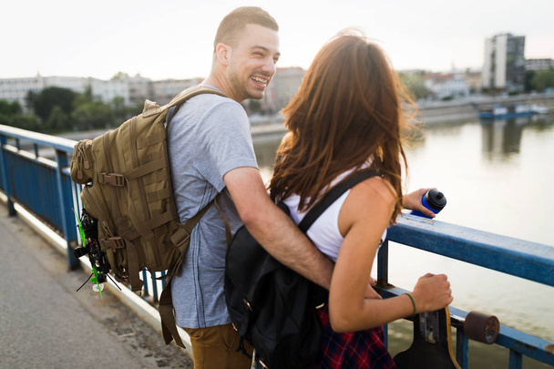 Picture of young attractive couple carrying skateboards - Photo, Image
