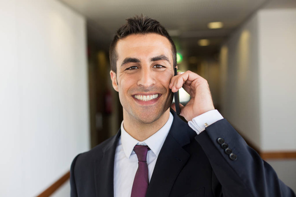 smiling businessman calling on smartphone at hotel - Foto, Imagem