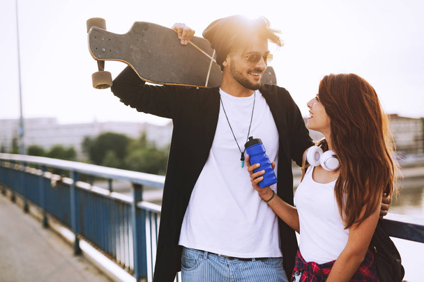 Picture of young attractive couple carrying skateboards - Fotoğraf, Görsel
