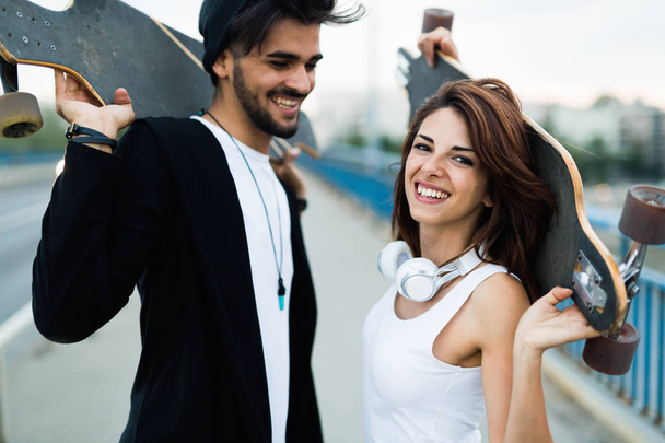 Image de jeune couple attrayant portant des planches à roulettes
 - Photo, image
