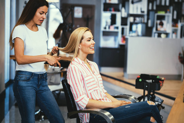 Portrait of beautiful young woman getting haircut - Photo, image