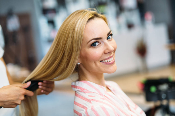 Portrait of beautiful young woman getting haircut - Foto, Imagen