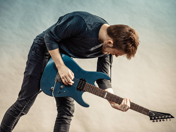 Young man playing electric guitar - Foto, afbeelding