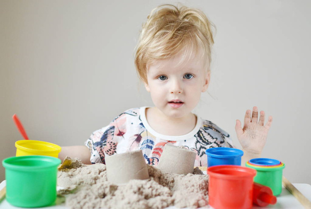 Κοριτσάκι παίζει με κινητική άμμος στο σπίτι  - Φωτογραφία, εικόνα