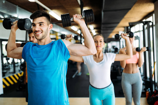 Group of friends exercising together in gym - Photo, image