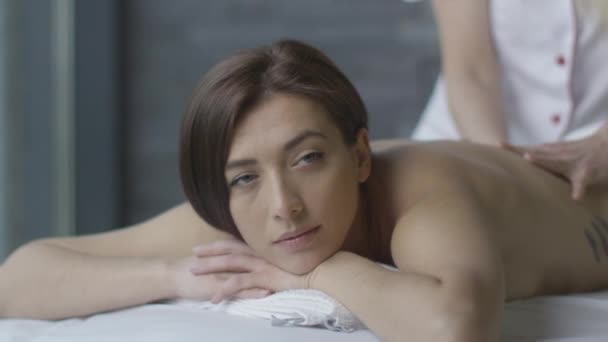junge schöne Frau bekommt eine entspannende Massage im Wellness-Center. - Filmmaterial, Video
