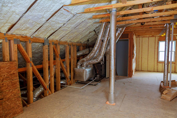 Aislamiento de espuma de plástico instalado en el techo inclinado de una nueva casa de marco
. - Foto, Imagen