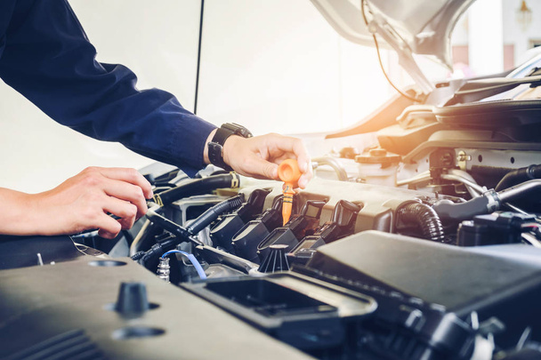 Mechanic changing oil mechanic in auto repair service. - Foto, afbeelding