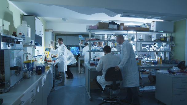 Timelapse beelden van een team van wetenschappers in witte jassen die in een moderne laboratorium werken. - Video