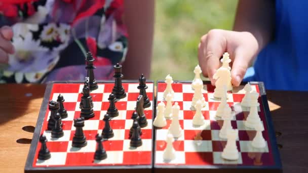 Child hands playing chess in nature. close up - Filmagem, Vídeo
