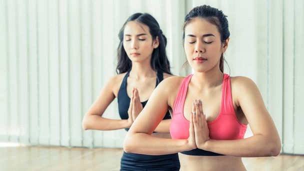 Женщины практикующие йогу позируют в тренажерном зале
 - Фото, изображение
