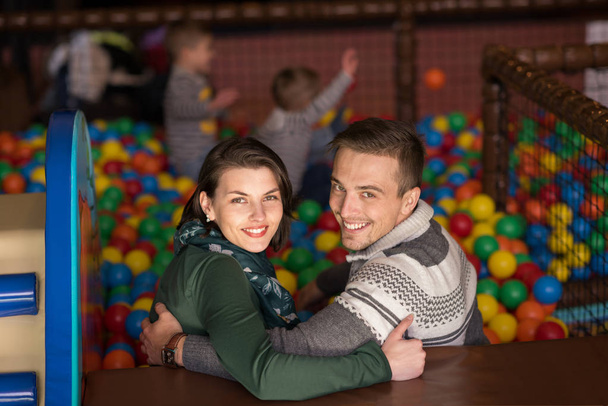 young parents with kids in a children's playroom - Фото, зображення