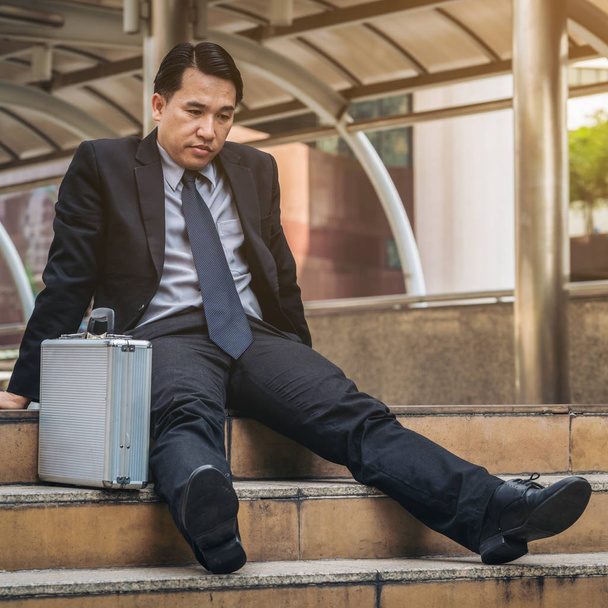 Hombre de negocios desesperado sentado irremediablemente en el suelo de la escalera
 - Foto, imagen