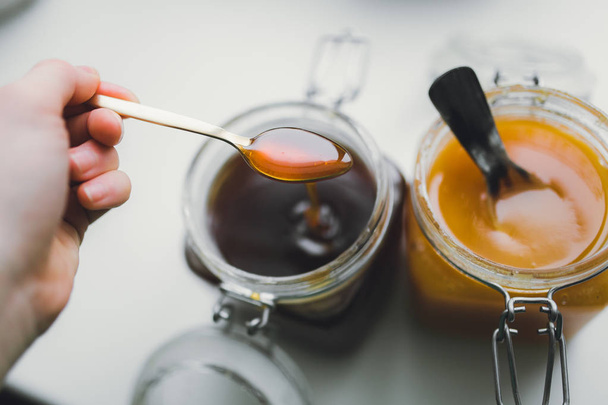 hand holding golden spoon with honey - Foto, Imagen