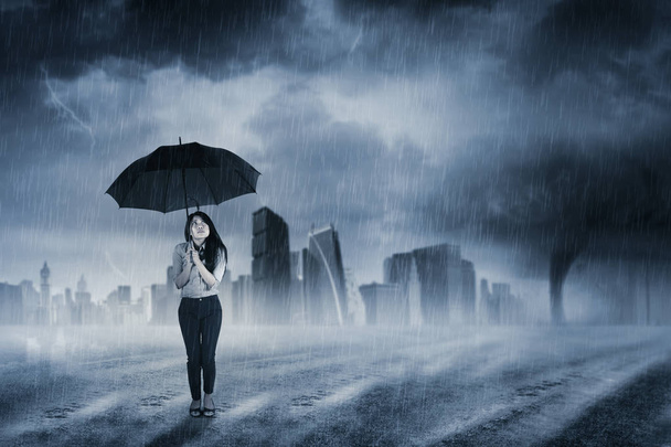 Businesswoman with umbrella standing in rain - Fotoğraf, Görsel