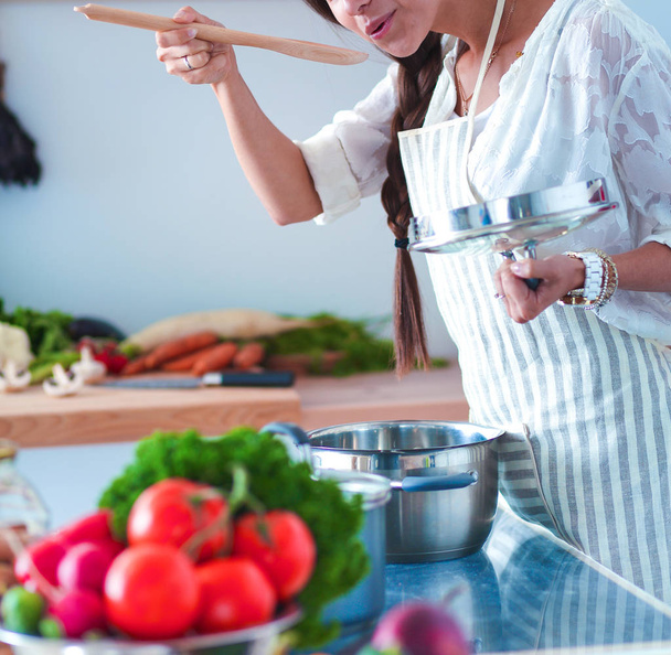 Cooking woman in kitchen with wooden spoon - Foto, Imagem