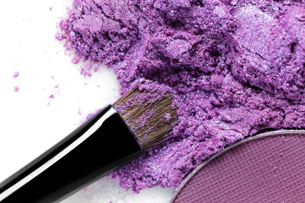 crushed purple eye shadow and makeup brush isolated on white background - Foto, afbeelding
