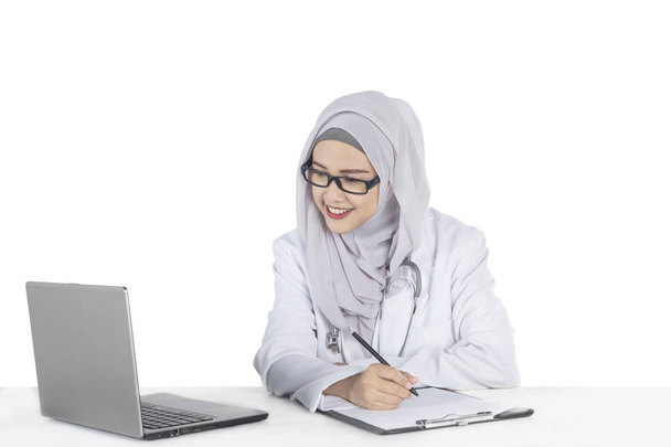 Muslim doctor with a laptop and clipboard - Фото, изображение