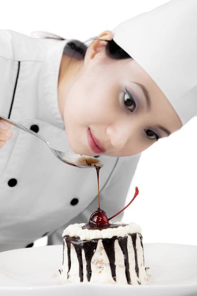 Pretty chef garnish a delicious cake - Fotó, kép