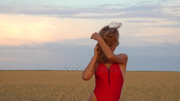 Mädchen auf einem Feld in einem roten Badeanzug. slowmo 120fps - Filmmaterial, Video
