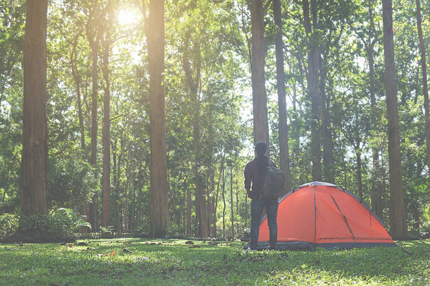 Asian hipster cute teen girl enjoying sunrise outside the tent. camping in forest. Outdoor Lifestyle.selective focus. - Foto, Bild