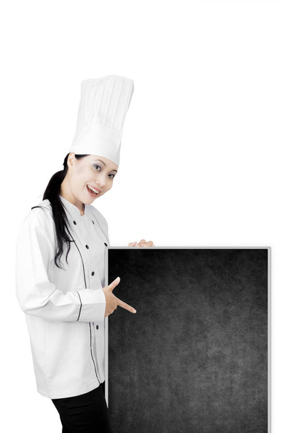Young chef showing an empty blackboard - Foto, immagini
