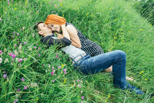 Młoda szczęśliwa para piękny mężczyzna i Kobieta, leżąc na zewnątrz na jasny, słoneczny dzień na zielony trawnik - Zdjęcie, obraz
