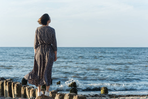 Beautiful girl in a dress posing near the sea - Fotó, kép