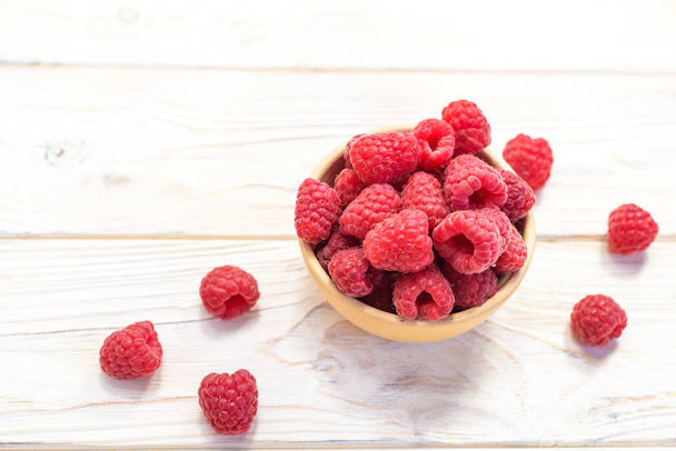 Raspberries bowl on rustic wood background, top view with copy space. Organic berries on wooden table - Photo, Image