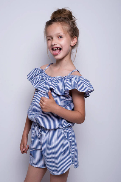 Beautiful little fashion model on white background. Portrait of cute smiling girl posing in studio. - Fotoğraf, Görsel