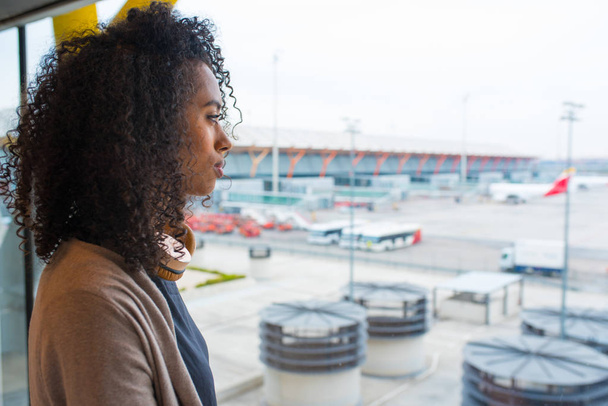 black woman looking trough airport window  - Valokuva, kuva
