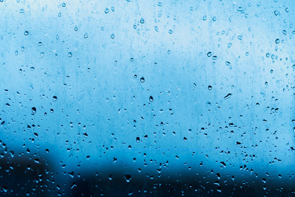Drops from the rain on the window pane. Abstract blue, contrasting background with natural water - Photo, Image