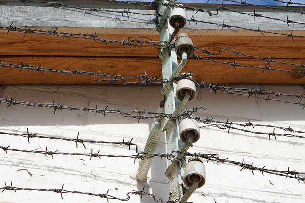Windows vězení buněk za plotem s ostnatým drátem pod vysokým napětím, detail - Fotografie, Obrázek