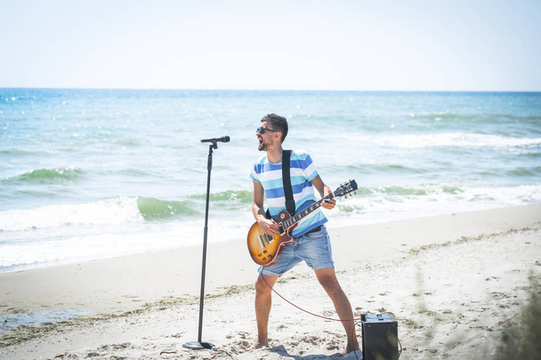 хлопець на пляжі з музичними інструментами
 - Фото, зображення