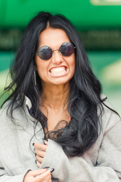 Bela menina de cabelos escuros posa em óculos escuros
 - Foto, Imagem