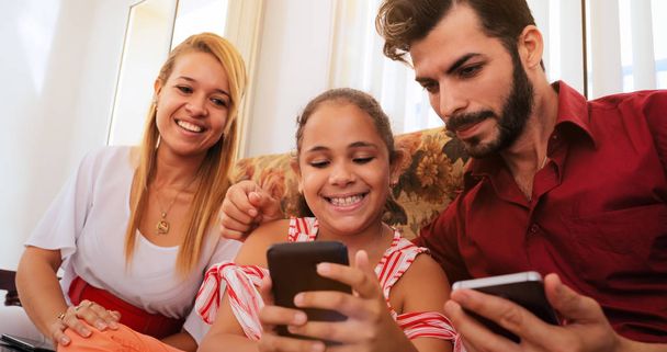Hispánský rodina směje, hrát hru na telefonu Smartphone - Fotografie, Obrázek