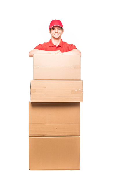 Guapo joven repartidor con cajas en blanco
 - Foto, Imagen