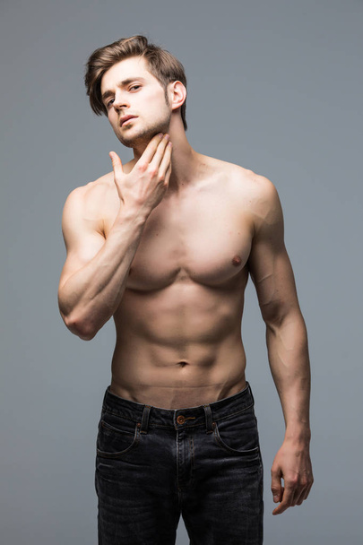 Retrato de fuerte sano guapo atlético hombre fitness modelo posando pared gris
 - Foto, imagen