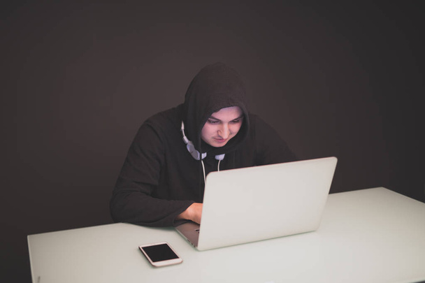 Hakkeri istuu pöydän ääressä pimeässä varastaa tietoja
 - Valokuva, kuva