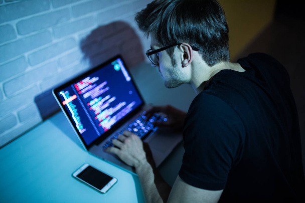 Χάκερ άνδρας προσπαθεί να παραβιάσει την ασφάλεια ενός συστήματος υπολογιστή αναζήτησης στο διαδίκτυο  - Φωτογραφία, εικόνα