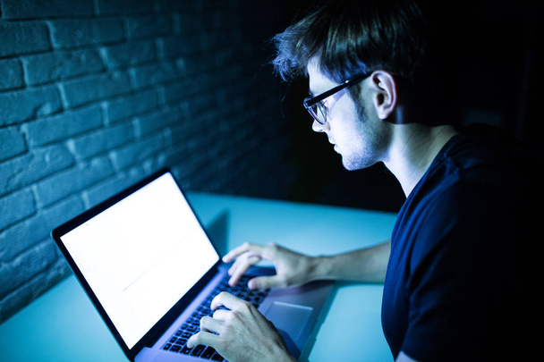 Hombre usando el ordenador portátil en la noche con espacio de copia de pantalla blanca
 - Foto, Imagen