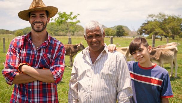 Ritratto di famiglia di tre generazioni di agricoltori in fattoria
 - Foto, immagini