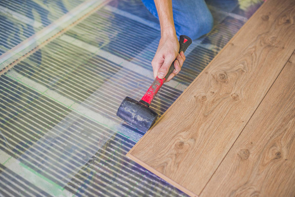 Man installing new wooden laminate flooring - Photo, Image