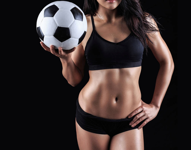 Beautiful body of fitness model holding soccer ball  - Фото, изображение
